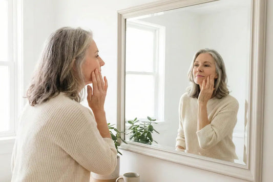 A woman looking at her menopausal skin on her face