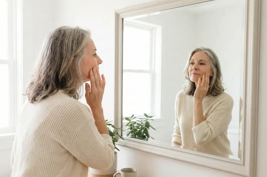 A woman looking at her menopausal skin on her face