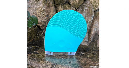 Silicone face cleansing brush resting on a bathroom surface, choosing a brush type for skin after 45