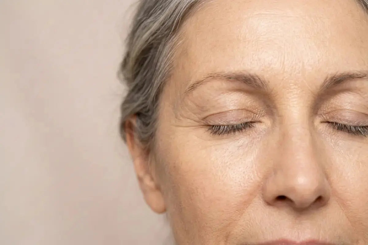 Close-up of menopausal woman with eye wrinkles and forehead lines, visible signs of collagen loss and skin thinning caused by declining estrogen levels during menopause