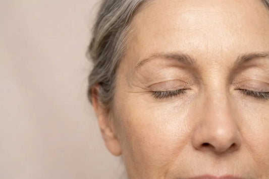 Close-up of menopausal woman with eye wrinkles and forehead lines, visible signs of collagen loss and skin thinning caused by declining estrogen levels during menopause