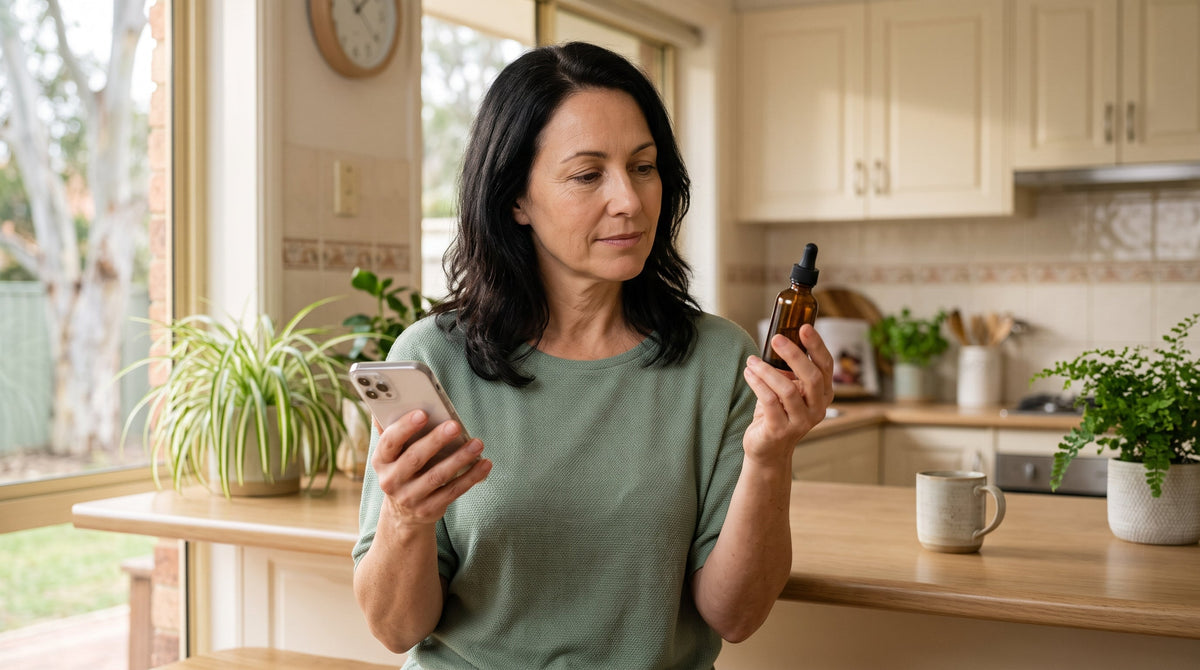 Woman in her fifties comparing a peptide serum bottle with information on her phone