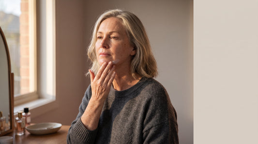 Woman in her fifties applying firming cream along her jawline, RF skin tightening or daily skincare after 45