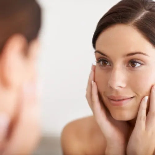 Woman applying firming cream to improve skin firmness on the face and neck