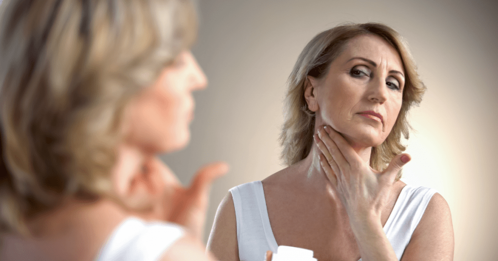 Woman over 45 applying a skin tightening cream to her neck and jawline