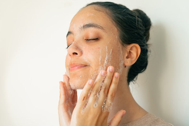 A woman cleansing her face with Active Foaming Cleanser