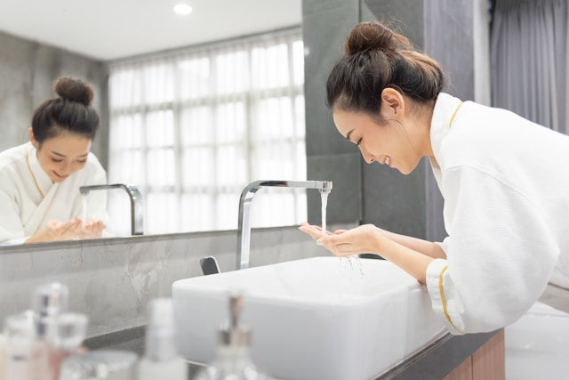 A woman washing her face.