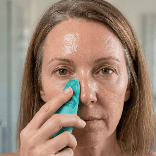 Mature woman gently cleansing her nose to clear blackheads on menopausal skin
