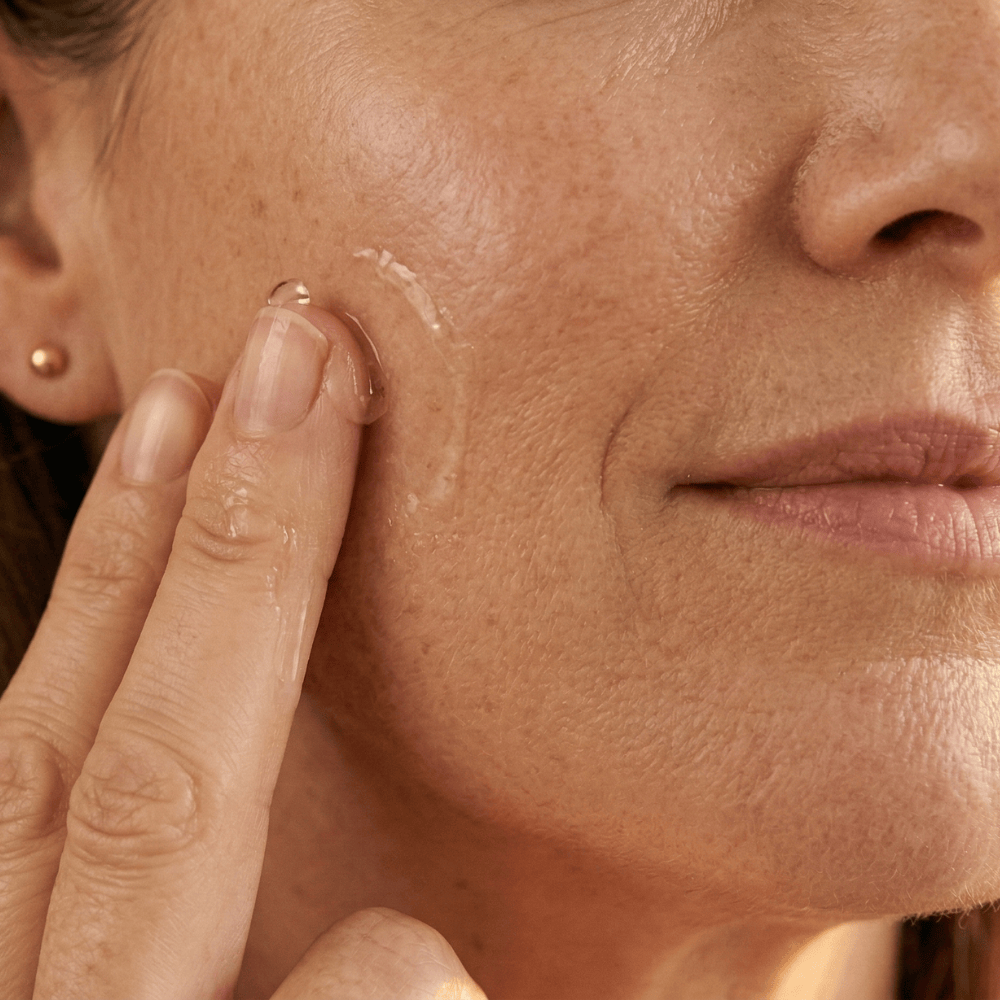 Close-up of applying anti-wrinkle serum to the cheek targeting fine lines and nasolabial folds on mature menopausal skin

