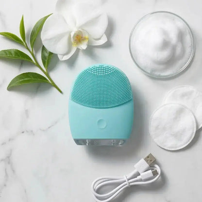 Genova GO Silicone Facial Cleanser flat lay with USB charging cable, cotton pads and cleansing foam on marble, rechargeable face cleansing device for sensitive mature skin