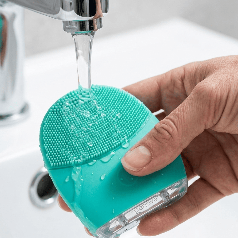 Genova GO Silicone Facial Cleanser being rinsed under running water, waterproof and easy to clean hygienic silicone face cleansing device that resists bacteria buildup