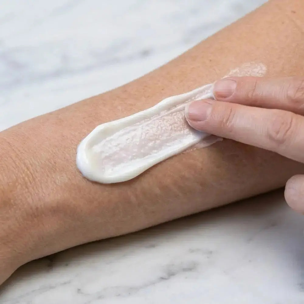 Applying Genova Stretch Mark Cream to skin with visible stretch marks, showing rich cream texture and how to use stretch mark cream on affected areas