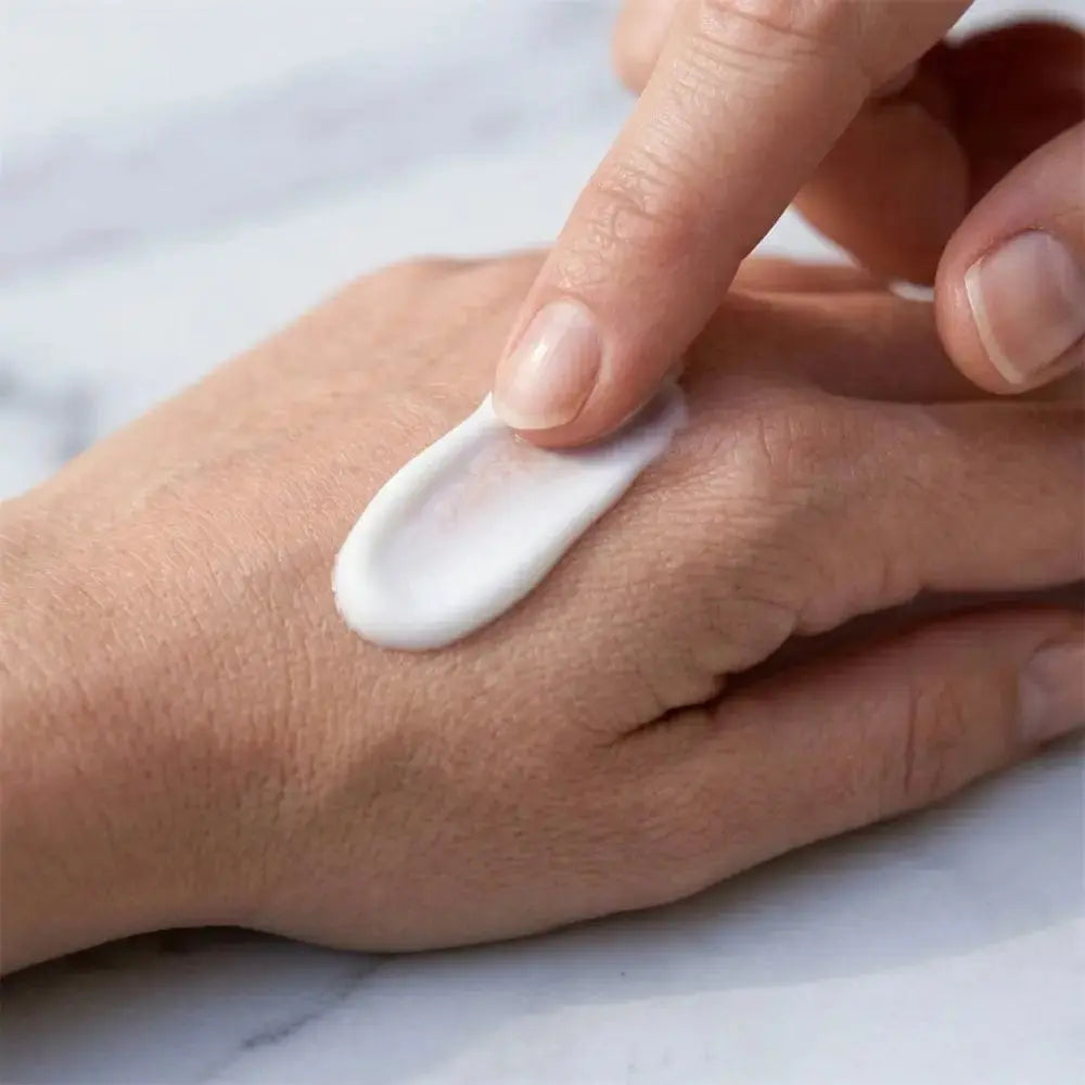 Genova Skincare Blemish Treatment white cream texture being smoothed across back of hand showing lightweight non greasy consistency