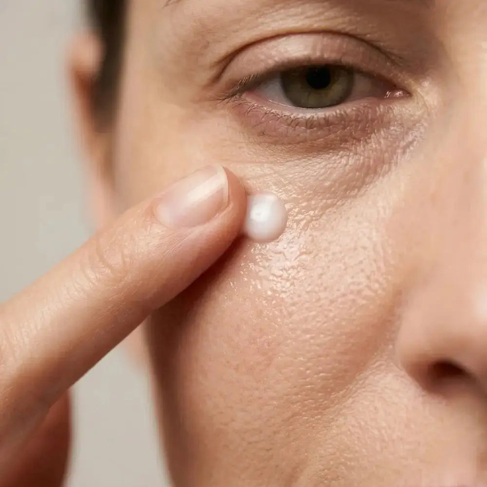 Applying Genova Perfecting Eye Serum under the eye on mature skin with visible fine lines and crepey texture, targeted treatment for menopausal under-eye concerns
