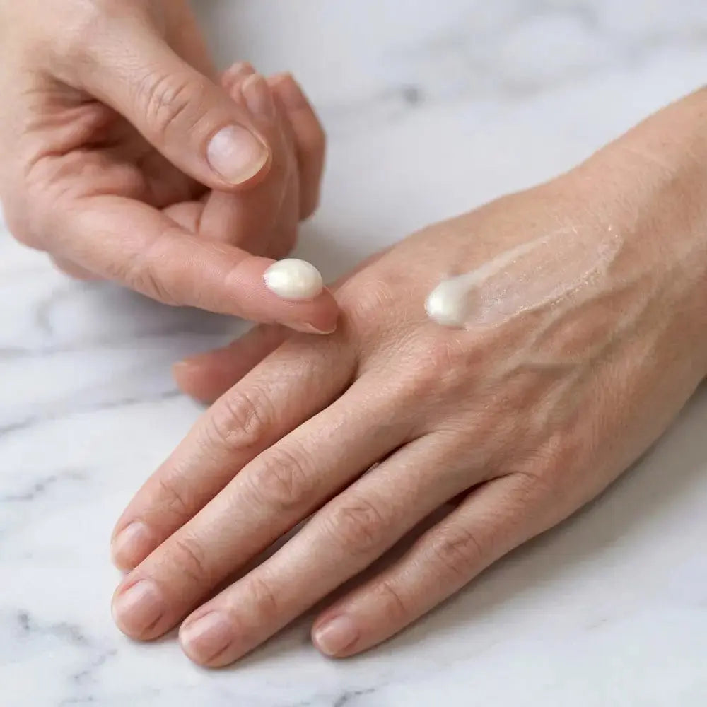 Applying Genova Skin Brightening Serum to the back of the hand, showing lightweight texture and smooth absorption for daily brightening skincare